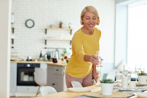 Smiling woman putting flute on table