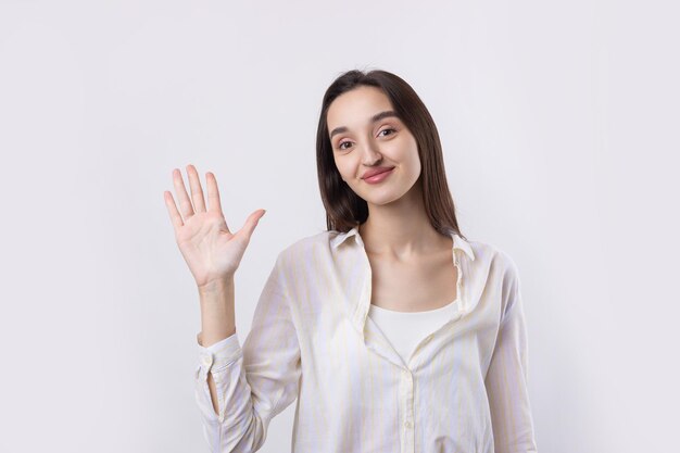 Photo smiling woman raised her hand palm up and forward like waving