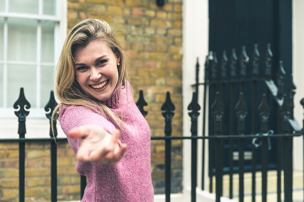 Photo smiling woman reaching out with her hand