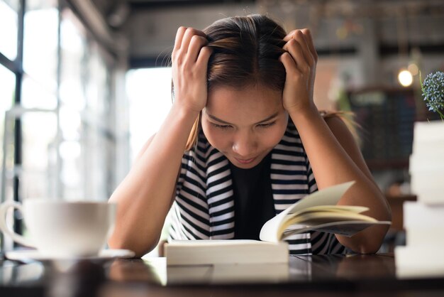 写真 笑顔の女性が本を読んでいる