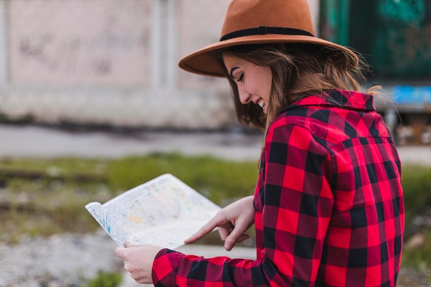 Photo smiling woman reading map at shunting yard