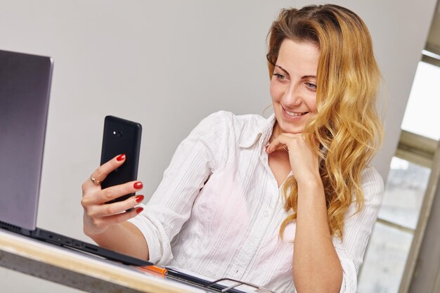 Smiling woman reading something on her mobile phone