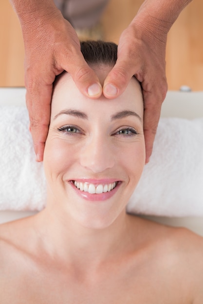 Smiling woman receiving head massage 