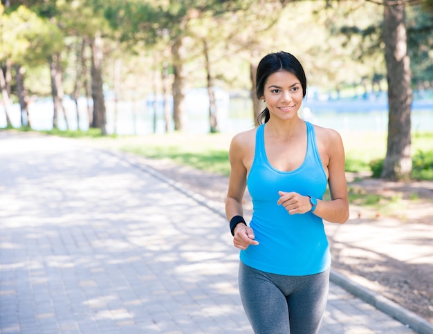 Smiling woman running in park