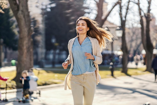 A smiling woman running in park