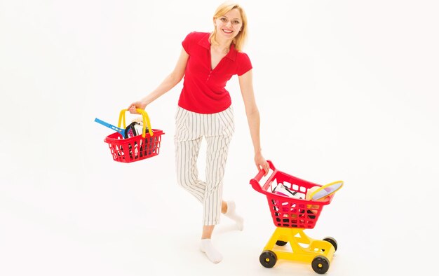 スポーツ店で買い物をする笑顔の女性 ショッピングバスケットとショッピングカートを持つ幸せな女の子