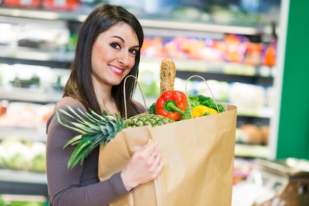 Smiling woman shopping in a supermarket