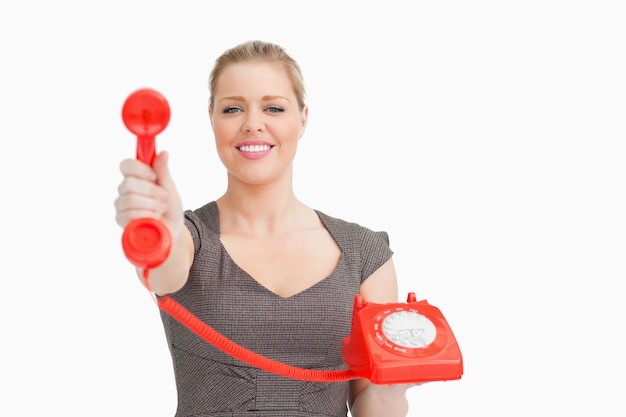 Smiling woman showing a retro phone