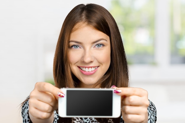 Smiling woman showing smartphone screen