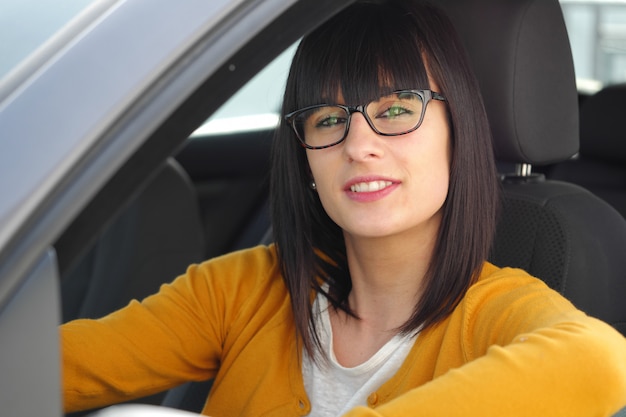 Donna sorridente che si siede in automobile