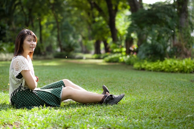 smiling woman sitting on grass in park