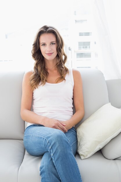 Smiling woman sitting on sofa in living room