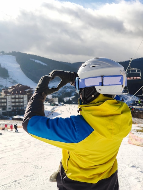 Smiling woman in ski outfit making heart love symbol of hands
winter leisure activities