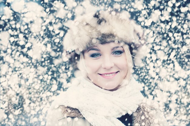 雪の冬の背景で笑顔の女性