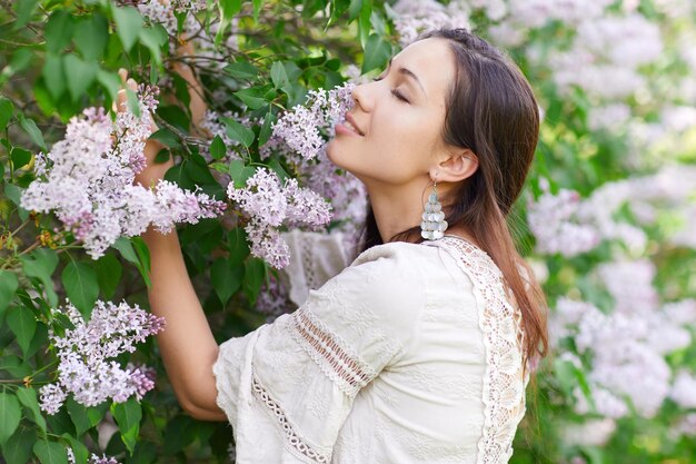 Smiling woman standing by white flowering plants