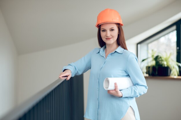 Smiling woman standing indoors with drawings