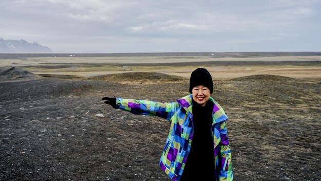 Foto donna sorridente in piedi sulla terra contro il cielo