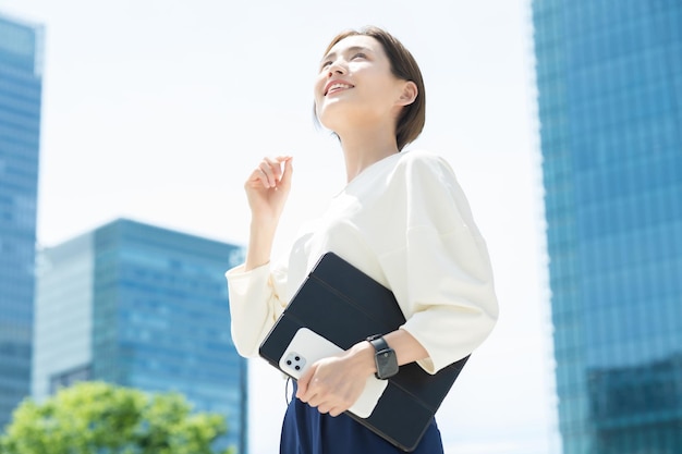 オフィス地区に立っている笑顔の女性