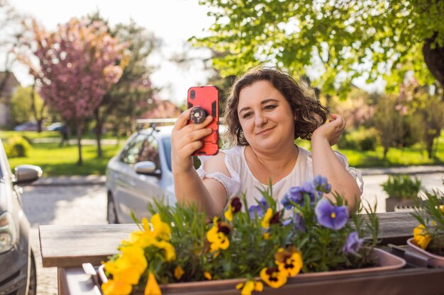 Foto donna sorridente in strada tramite cellulare e videochiamata