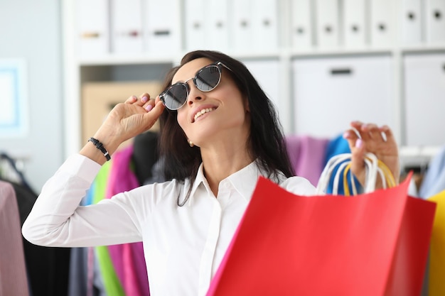 Smiling woman in sunglasses with shopping bags