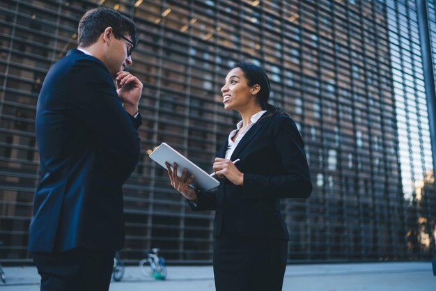 Smiling woman surveying young formal man