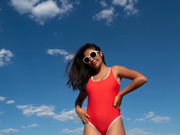 Smiling woman in swimsuit against blue sky