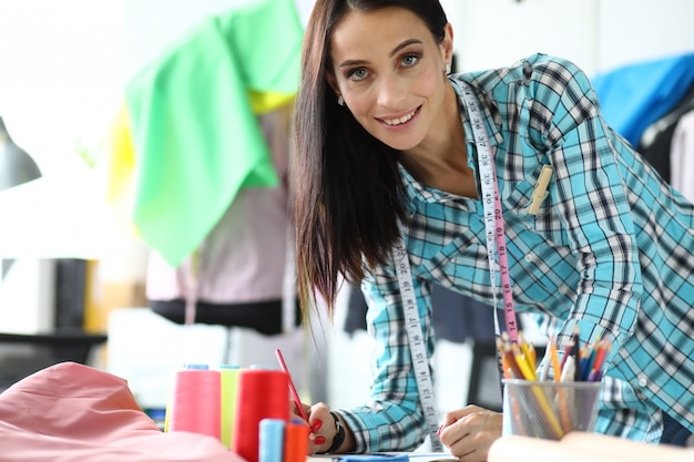 Smiling woman tailor on workshop portrait.