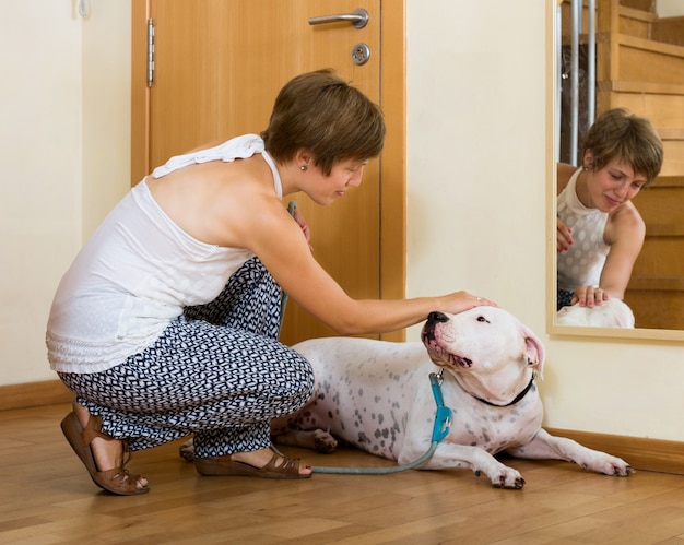 smiling woman taking dog for a walk