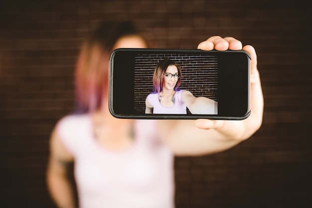 Foto donna sorridente che prende selfie dal telefono cellulare