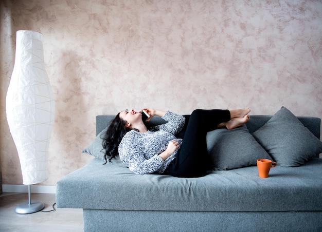 Foto donna sorridente che parla al cellulare a casa