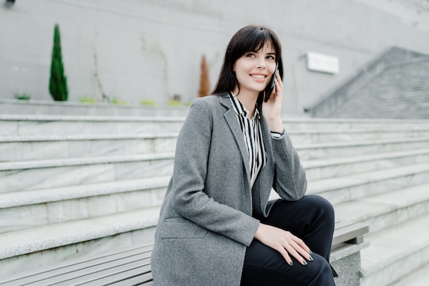 Donna sorridente che parla sul telefono all'aperto