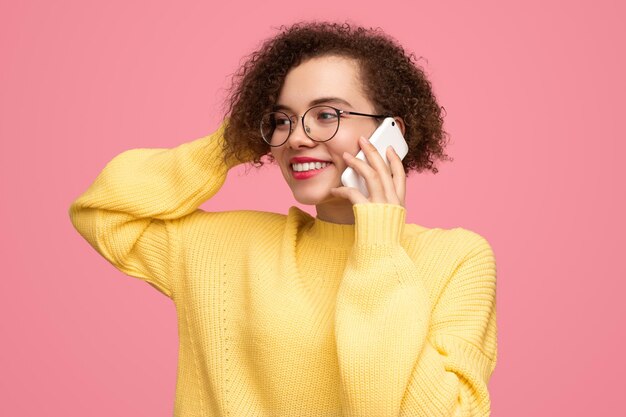 Smiling woman talking on smartphone in studio