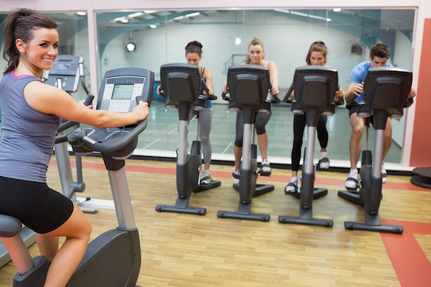 Smiling woman teaching spinning class