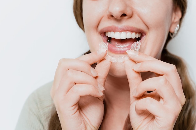smiling woman using clear teeth aligner