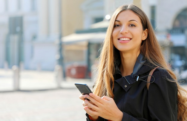 スマートフォンを使って笑顔の女性