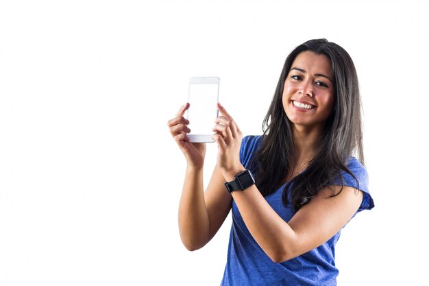 Smiling woman using a smartphoen and wearing a smartwatch