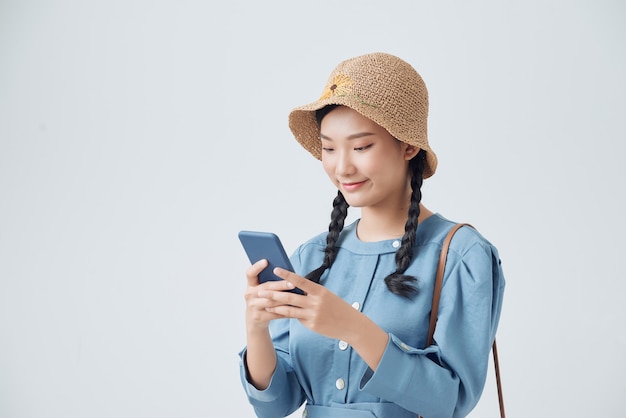 Smiling woman using smartphone on a gray background