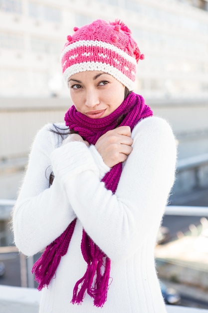 Donna sorridente che indossa una sciarpa e un cappello