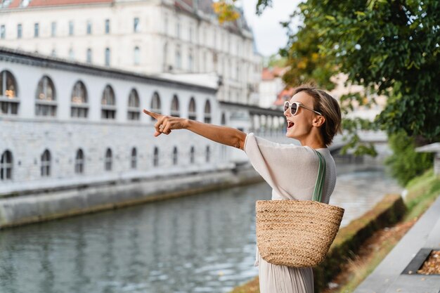 スロベニアの旧市街の通りを歩くスタイリッシュな服を着た笑顔の女性スロベニアヨーロッパ旅行