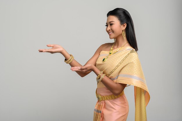 Smiling woman wearing traditional clothing gesturing against white background