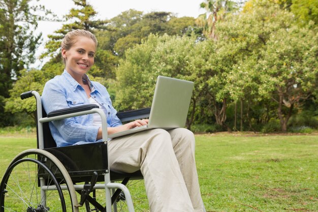 노트북으로 휠체어에 웃는 여자