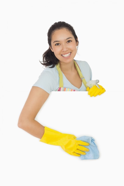 Smiling woman wiping down white surface