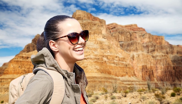 Photo smiling woman with backpack over grand canyon