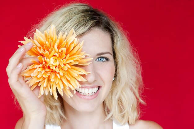 彼女の手に大きな花を持つ笑顔の女性