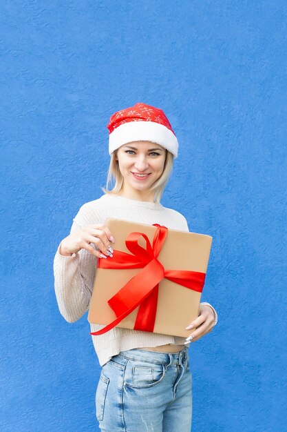 A smiling woman with a christmas present in her hands holidays and events christmas