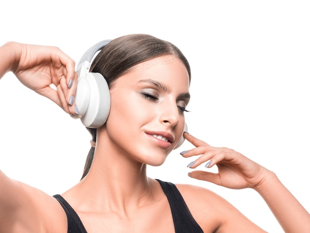 Smiling woman with closed eyes listening to the music via headphones