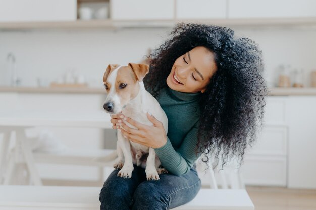 Foto donna sorridente con un cane a casa