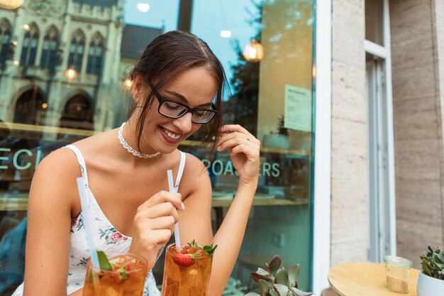Foto donna sorridente con un drink in bicchiere al ristorante
