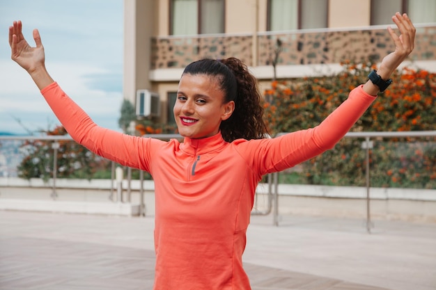 Photo smiling woman with dumbbell in her hands doing squats outside with a pool in the background fit wom