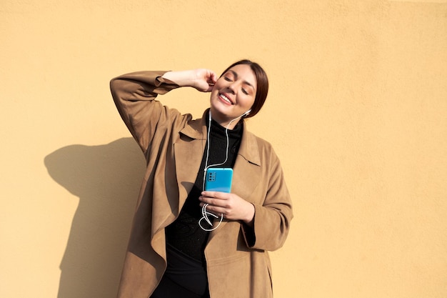 Smiling woman with eyes closed listening to music with headphones